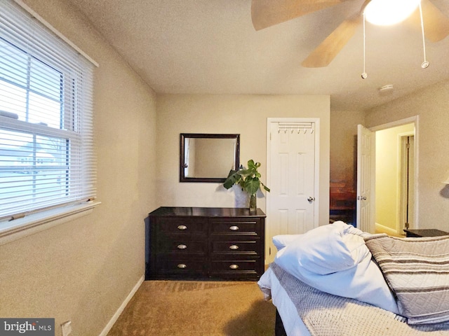 carpeted bedroom with ceiling fan and baseboards