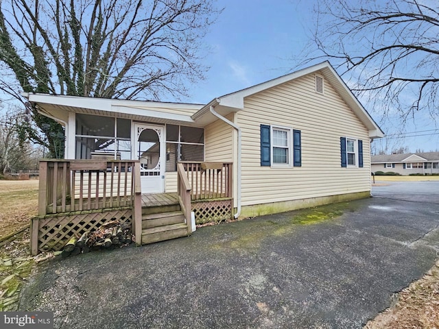 view of front facade with a sunroom and a wooden deck