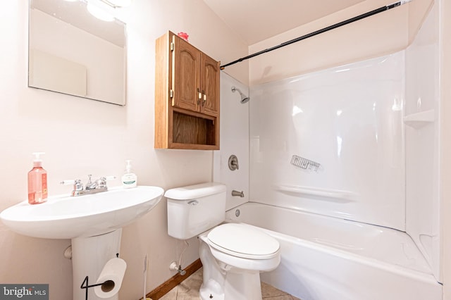 full bath featuring toilet, a sink, tile patterned flooring, tub / shower combination, and baseboards