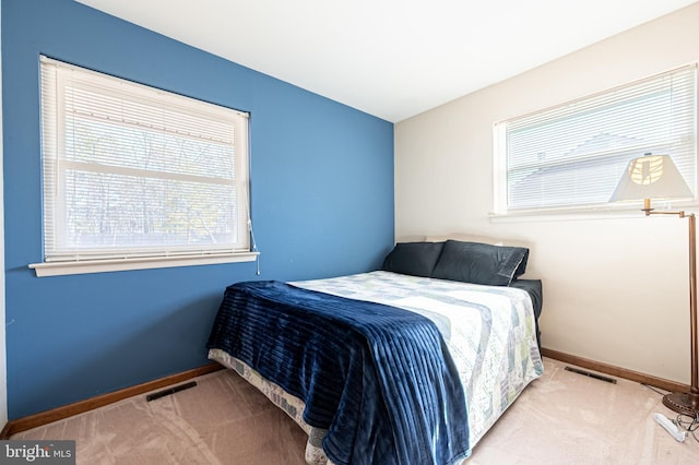 carpeted bedroom with visible vents and baseboards