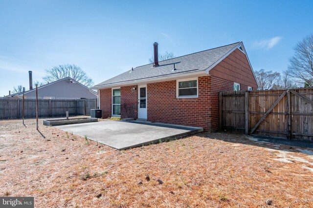 back of house with a patio, a gate, cooling unit, a fenced backyard, and brick siding