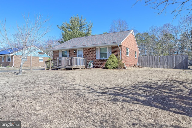 single story home featuring brick siding, roof with shingles, and fence