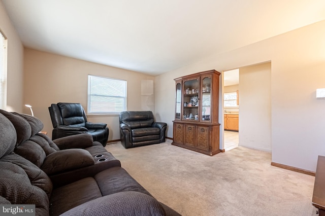 living room with baseboards and light carpet