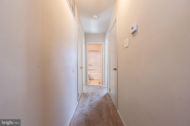 hall featuring visible vents, baseboards, and carpet