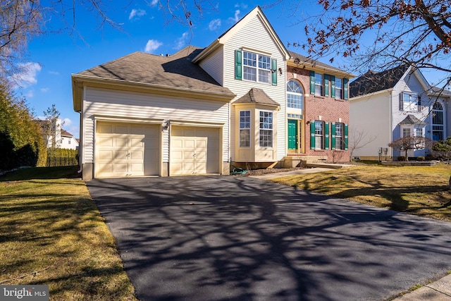 view of front of house featuring a garage, aphalt driveway, and a front yard