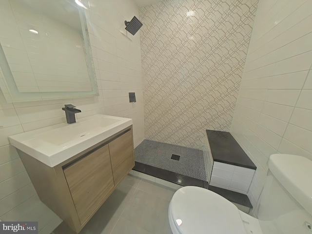 bathroom featuring toilet, tiled shower, and tile walls