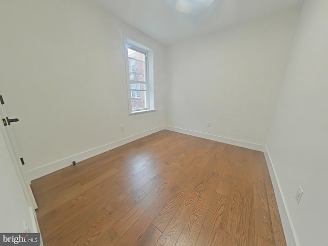 empty room with wood finished floors and baseboards