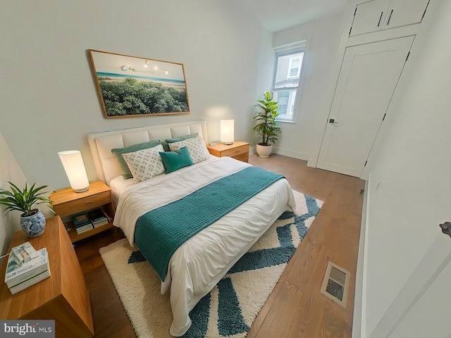 bedroom with visible vents and wood finished floors