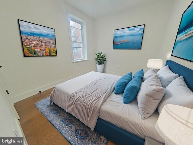 bedroom featuring baseboards and wood finished floors