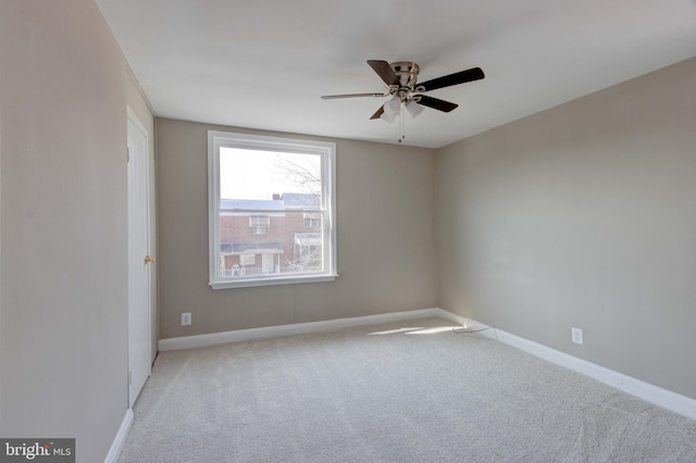 spare room with a ceiling fan, carpet, and baseboards