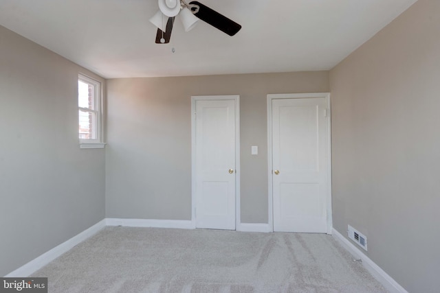 unfurnished bedroom with ceiling fan, carpet, visible vents, and baseboards