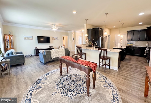 interior space with crown molding, recessed lighting, light wood finished floors, and ceiling fan