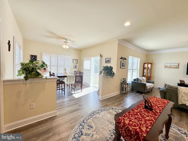 living room featuring baseboards, ornamental molding, recessed lighting, wood finished floors, and a ceiling fan