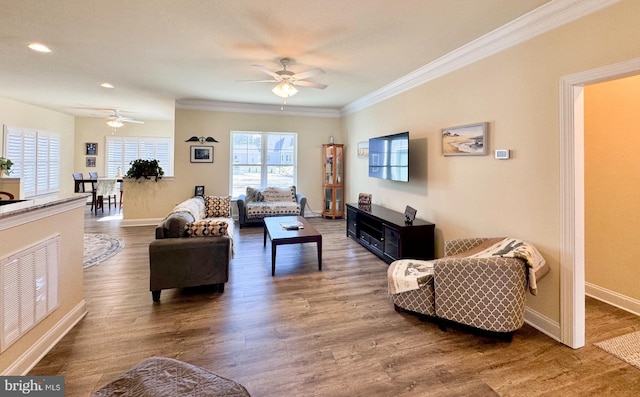 living area with ornamental molding, baseboards, and wood finished floors