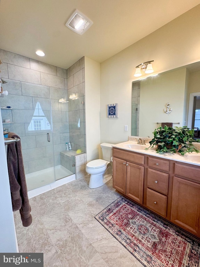 bathroom with a sink, toilet, a stall shower, and double vanity