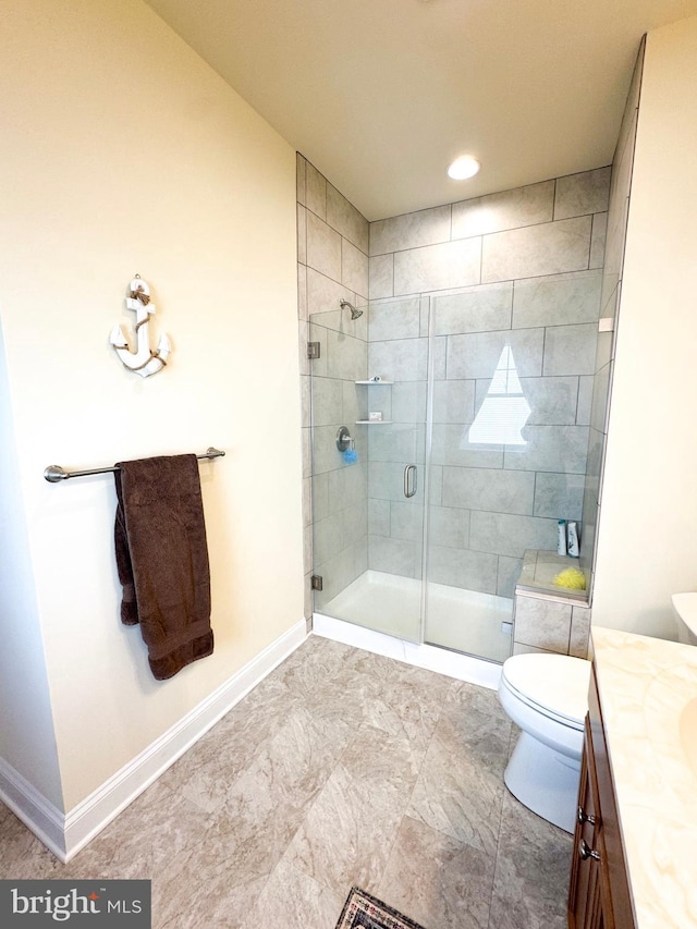 full bath with vanity, a shower stall, toilet, and baseboards