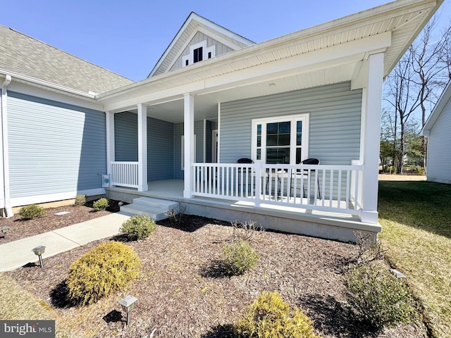 view of front of house with a porch and a shingled roof