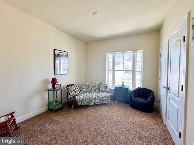 sitting room featuring baseboards and carpet floors