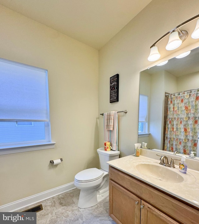 full bath with visible vents, curtained shower, baseboards, toilet, and vanity