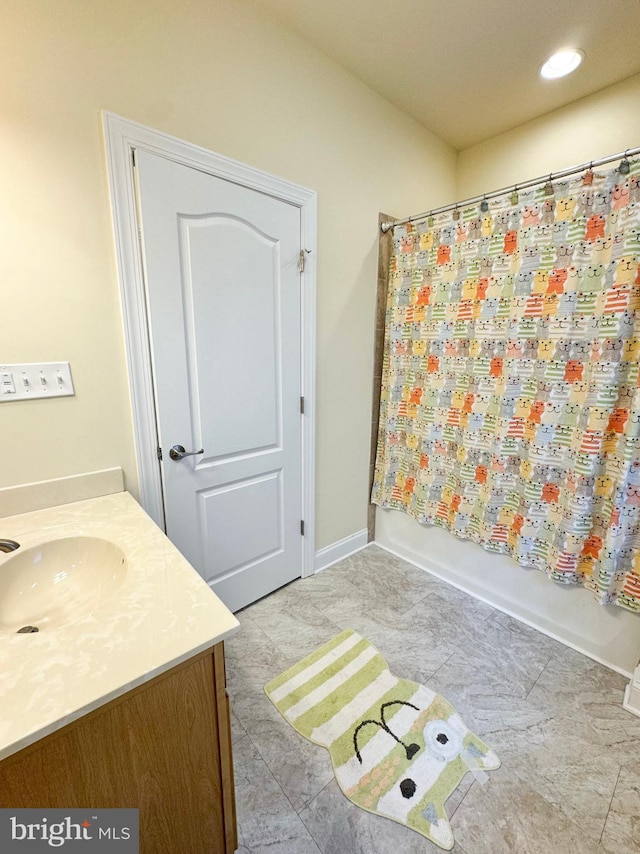 bathroom with recessed lighting, shower / bath combo with shower curtain, vanity, and baseboards