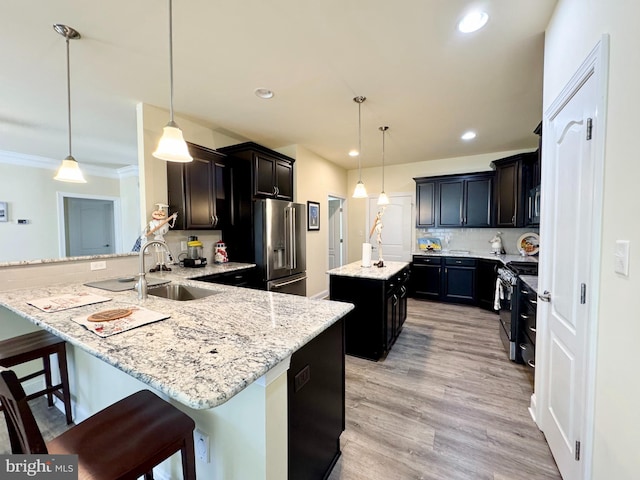 kitchen with light stone counters, a center island, appliances with stainless steel finishes, a peninsula, and decorative backsplash