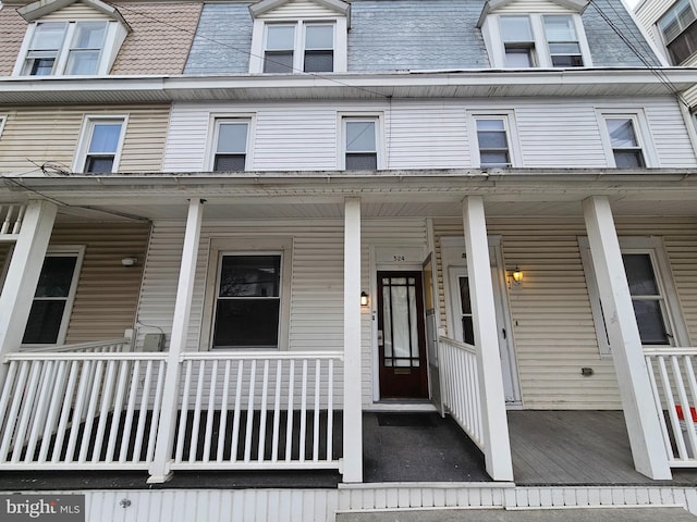 view of front of house featuring mansard roof and a porch