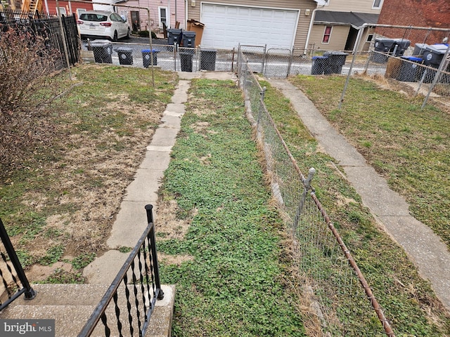 view of yard featuring concrete driveway and fence