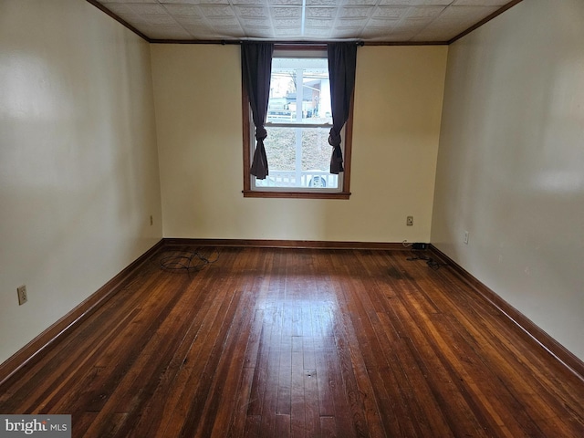 unfurnished room featuring crown molding, hardwood / wood-style floors, and baseboards