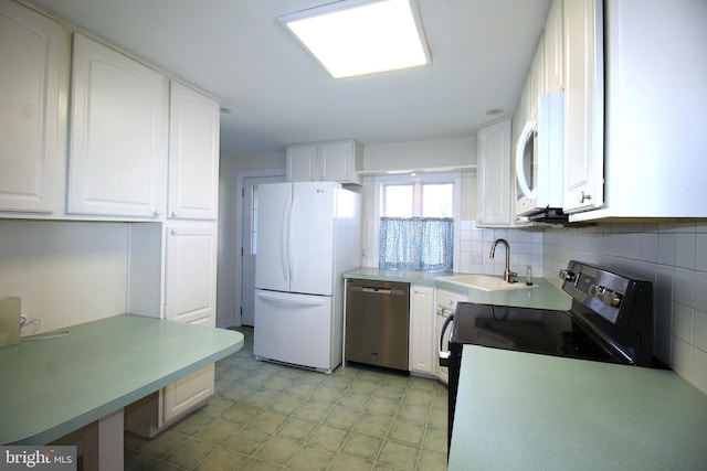 kitchen featuring tasteful backsplash, light countertops, appliances with stainless steel finishes, white cabinets, and a sink