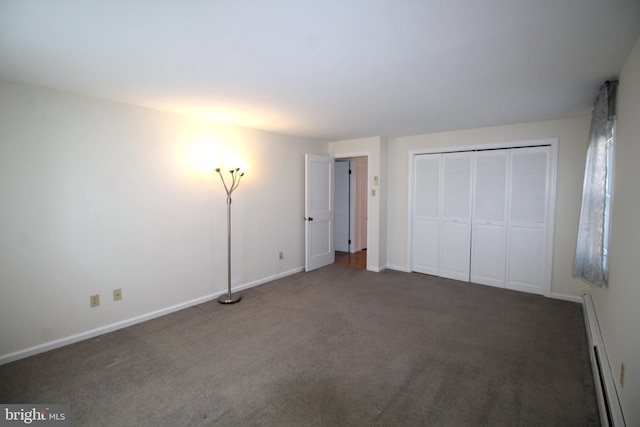 unfurnished bedroom featuring carpet floors, baseboards, baseboard heating, and a closet