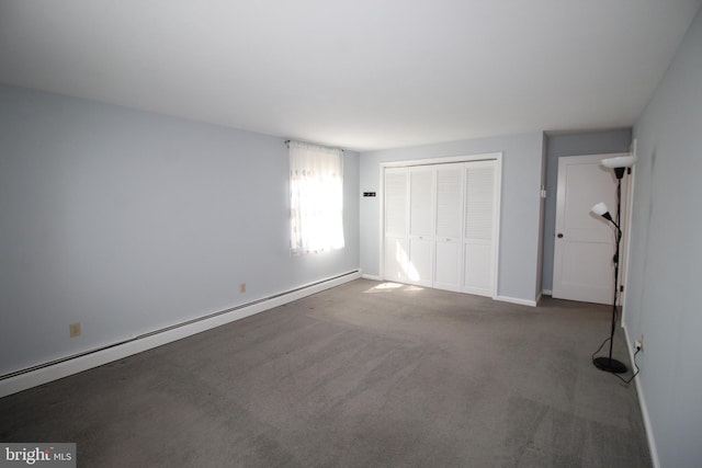 unfurnished bedroom with a baseboard heating unit, a closet, carpet flooring, and baseboards