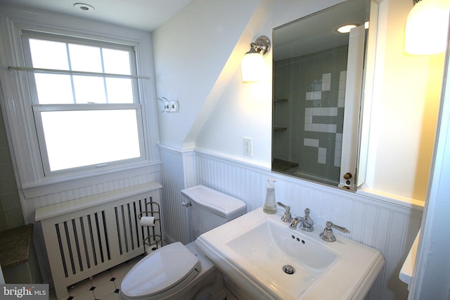 bathroom featuring wainscoting, a sink, toilet, and radiator