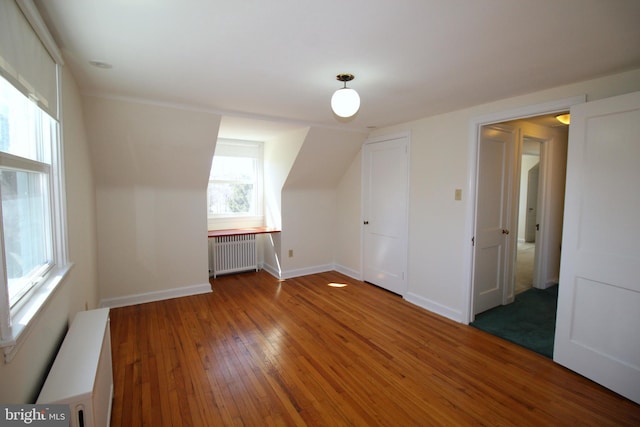 bonus room with radiator, baseboards, and hardwood / wood-style floors