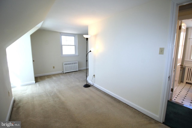 additional living space with radiator heating unit, baseboards, vaulted ceiling, and carpet flooring