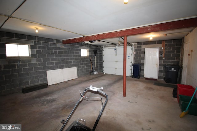 basement with a garage and concrete block wall