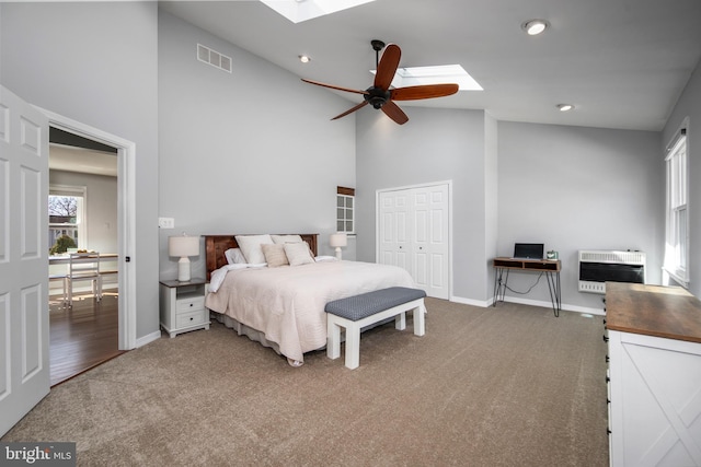 bedroom with heating unit, carpet, visible vents, baseboards, and a skylight