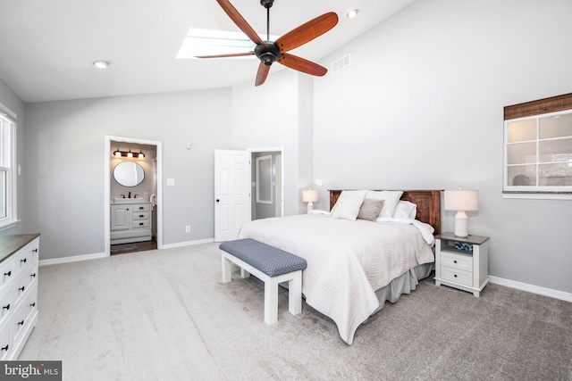 bedroom featuring visible vents, light carpet, a sink, a skylight, and baseboards