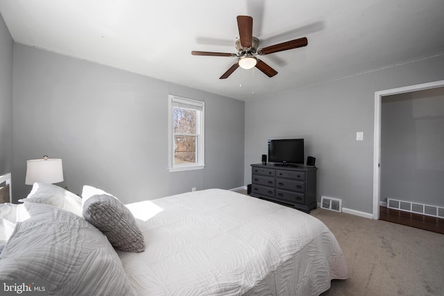 carpeted bedroom with visible vents, baseboards, and a ceiling fan