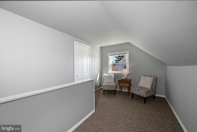 living area featuring baseboards, carpet, and vaulted ceiling