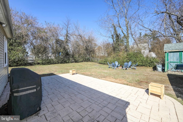 view of patio / terrace with an outbuilding, fence, and a shed