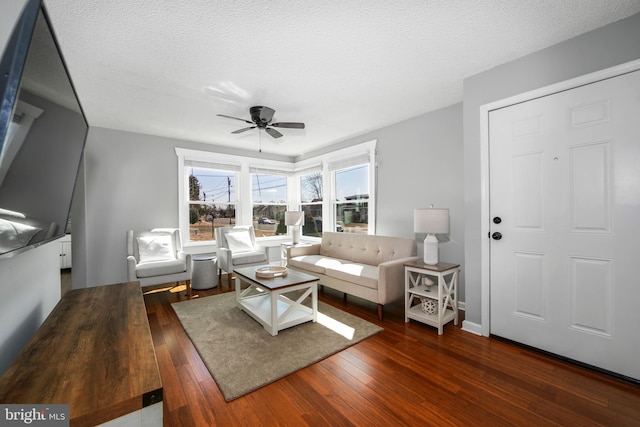 living area featuring a textured ceiling, ceiling fan, and wood-type flooring