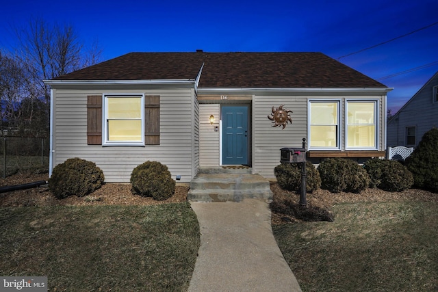 view of front of house with a front yard and roof with shingles