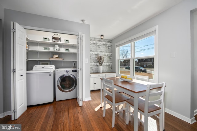 laundry room featuring washer and dryer, baseboards, dark wood-type flooring, and laundry area