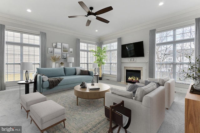 living room with ceiling fan, recessed lighting, a fireplace with flush hearth, and crown molding