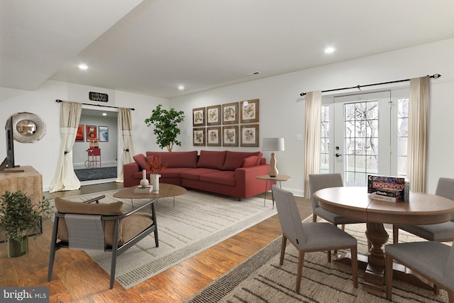 living area with baseboards, wood finished floors, and recessed lighting