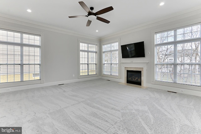 unfurnished living room featuring recessed lighting, a fireplace with flush hearth, baseboards, carpet, and crown molding