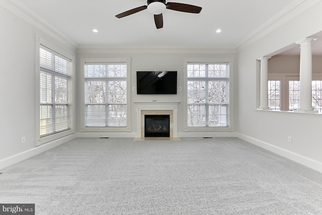 unfurnished living room with carpet floors, ornate columns, baseboards, and crown molding