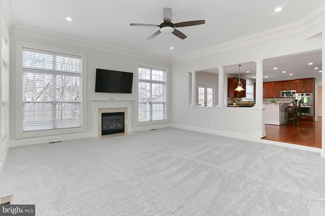 unfurnished living room with baseboards, carpet, a fireplace with flush hearth, and crown molding