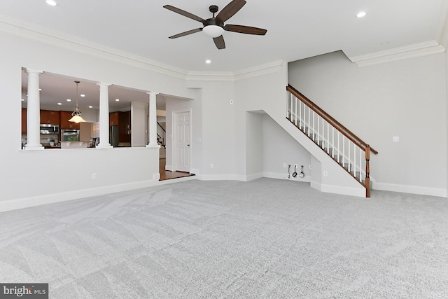 unfurnished living room with ornate columns, stairway, and ornamental molding