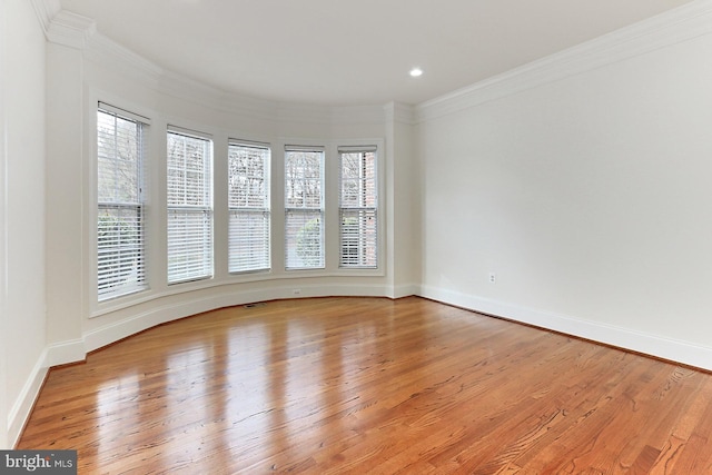 unfurnished room with light wood finished floors and crown molding